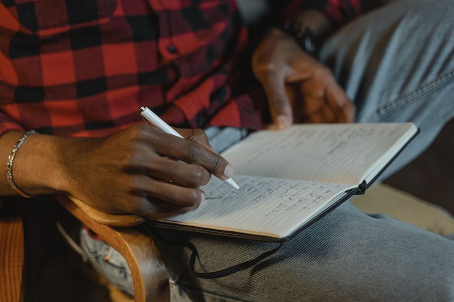 Person writing notes in a small notebook