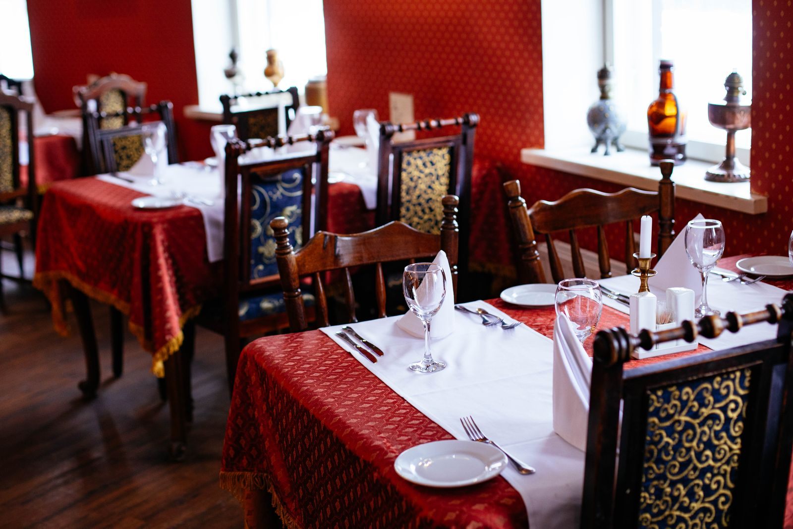 Formal dining room with red tablecloths and set tables